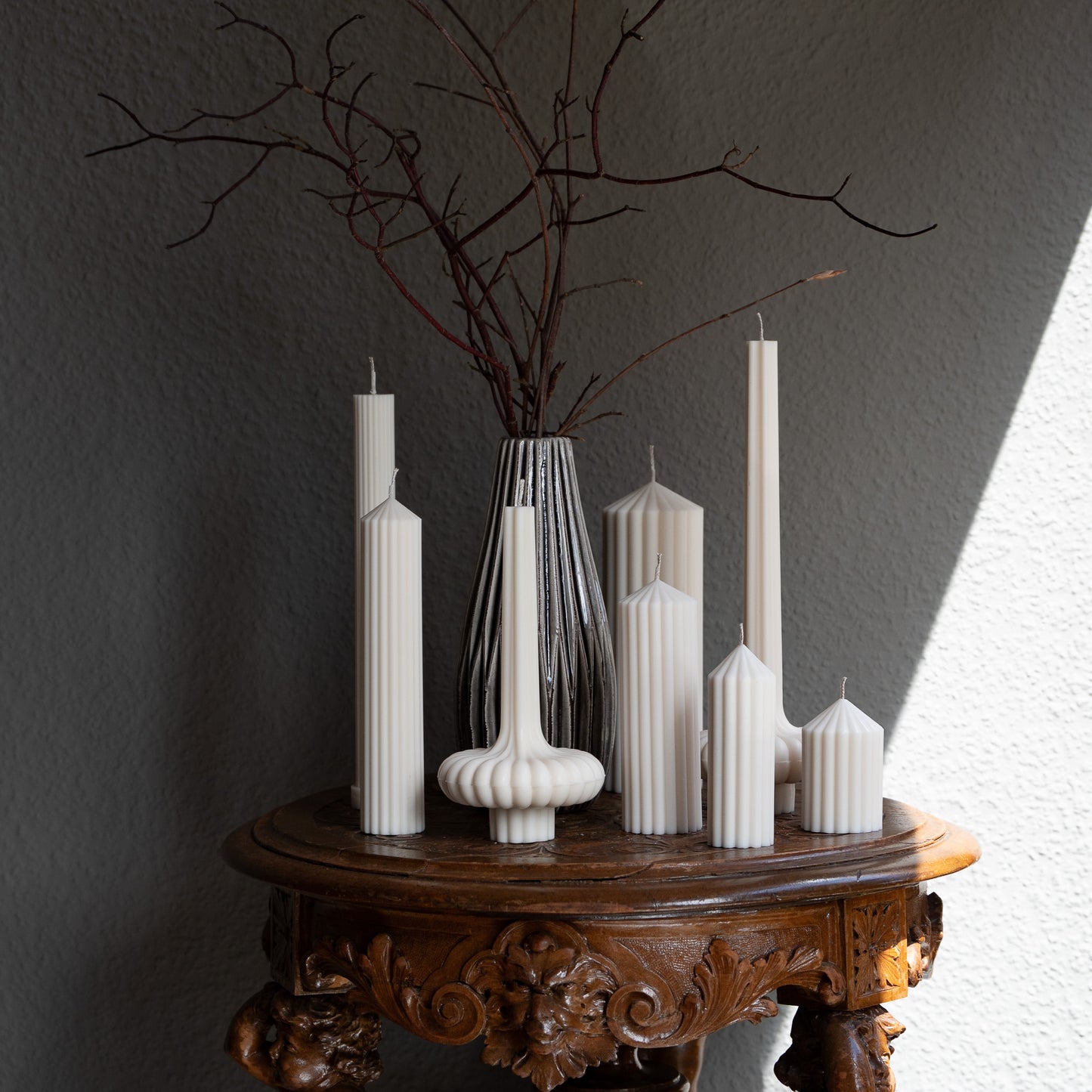Kerzen Set Blocka, Fylda und Skæva in natürlichem Cremeton – skulpturale Designkerzen, Rapswachs, handgefertigt in Hamburg, 100 % pflanzlich & nachhaltig. Studio Z. Stumpenkerzen in Riffelstruktur. Dekoriert auf barockem Tisch im Schatten-Lichtspiel der Sonne.