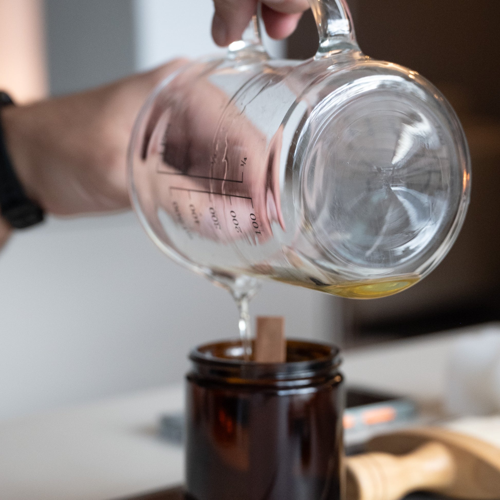 mann gießt Wachs in Gefäßkerze 