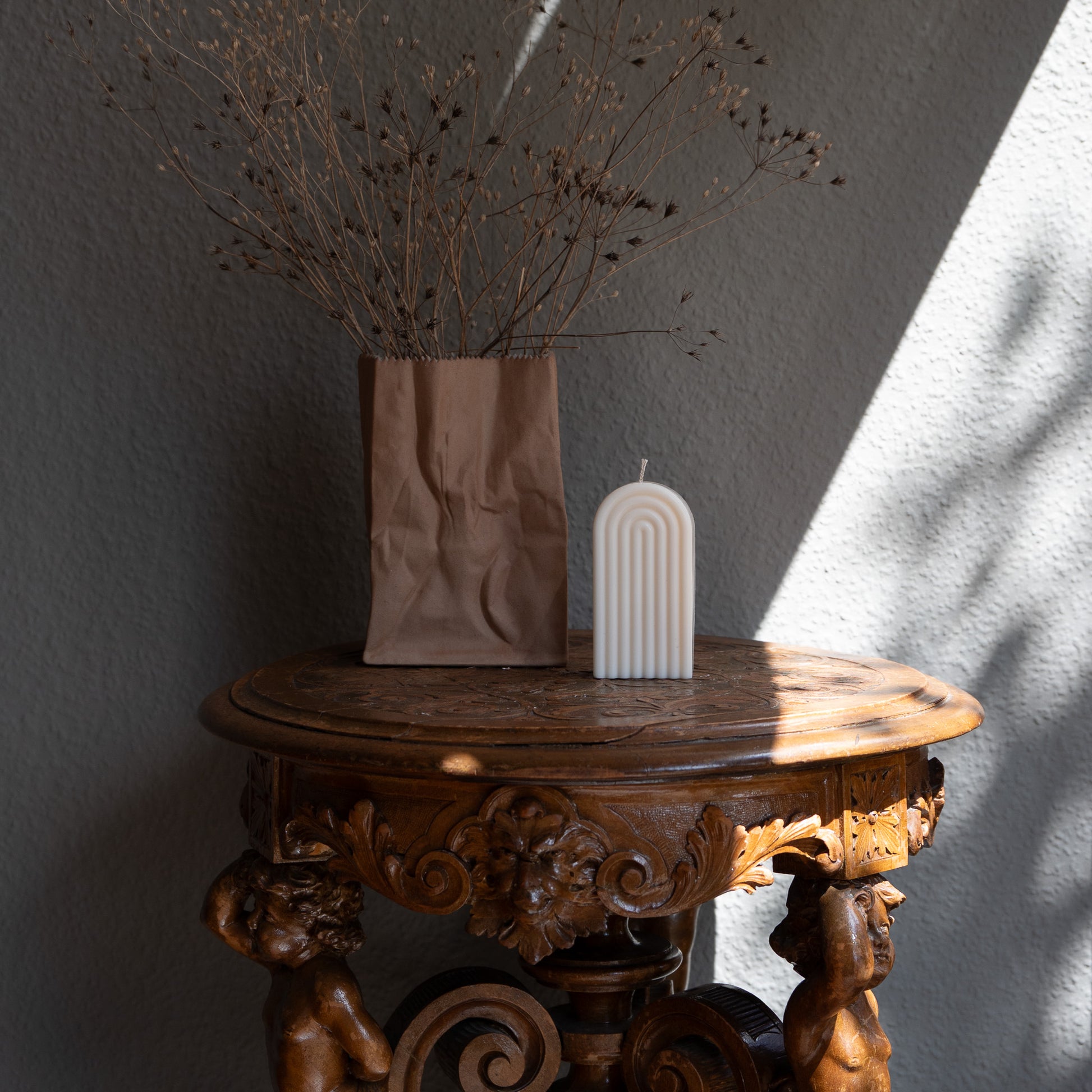 Kerzen Set Farverig in natürlichem Cremeton – skulpturale Regenbogen Designkerzen, Rapswachs, handgefertigt in Hamburg, 100 % pflanzlich & nachhaltig. Studio Z. Dekoriert auf barockem Tisch im Schatten-Lichtspiel der Sonne mit Vase.