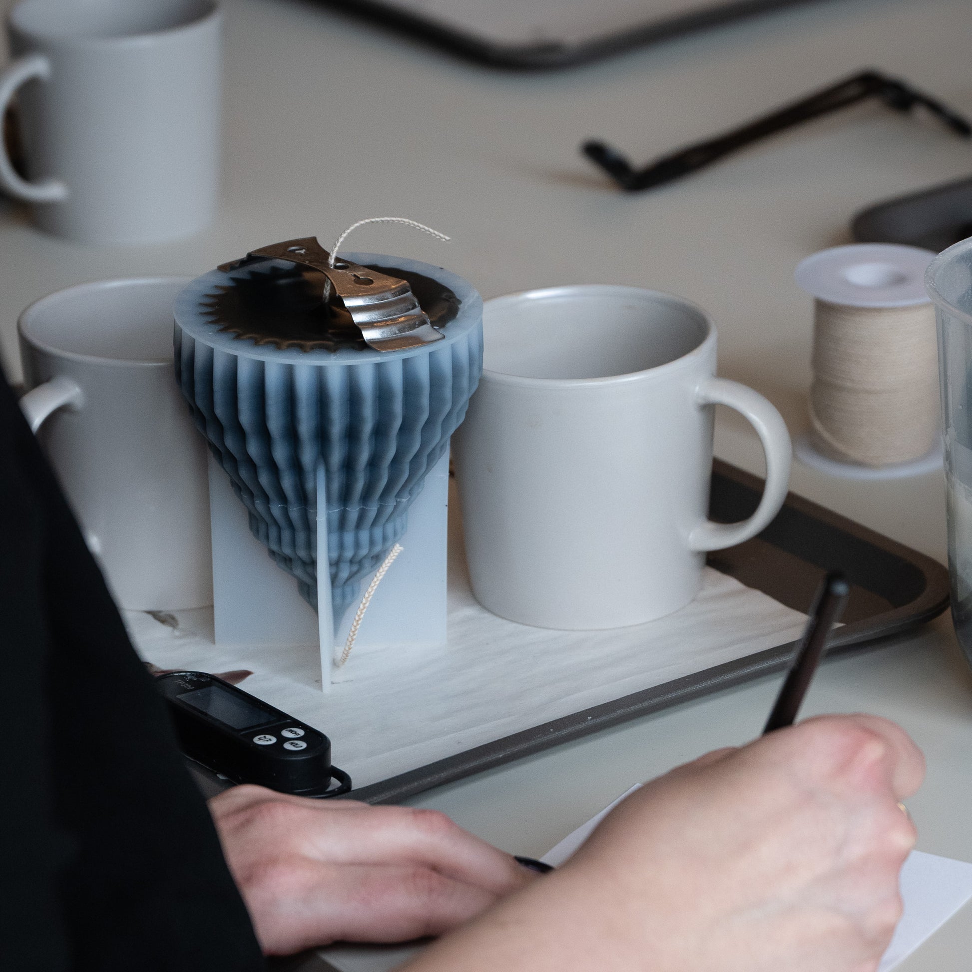 Kerzen Workshop Hamburg Frau schreibt etwas auf Tisch mit gegossener Kerze Tannenbaum 