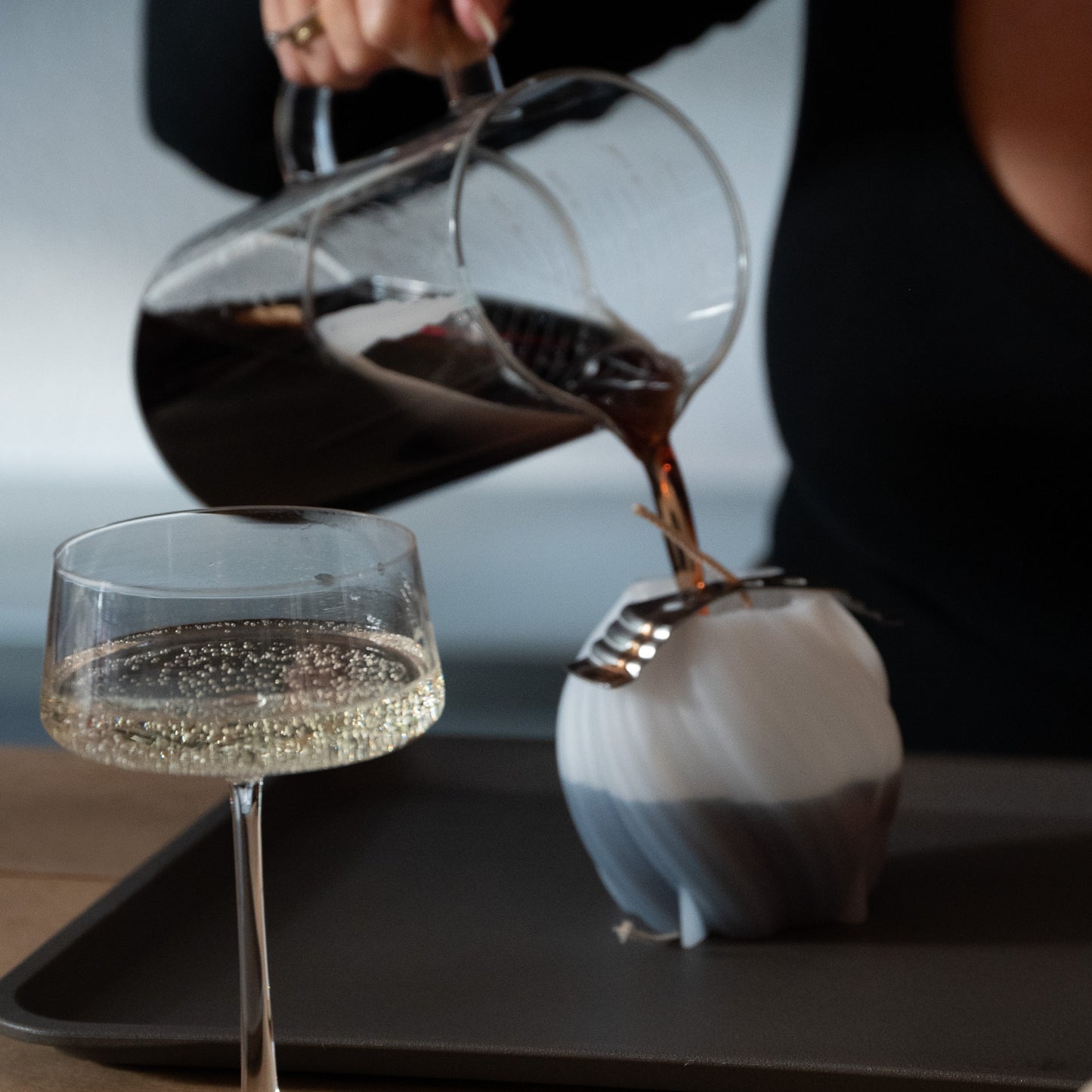 kerzen gießen cremant handcrafted hamburg frau gießt heißen rapsweachs mit farbe und duft in silikonform davor glas mit cremant 