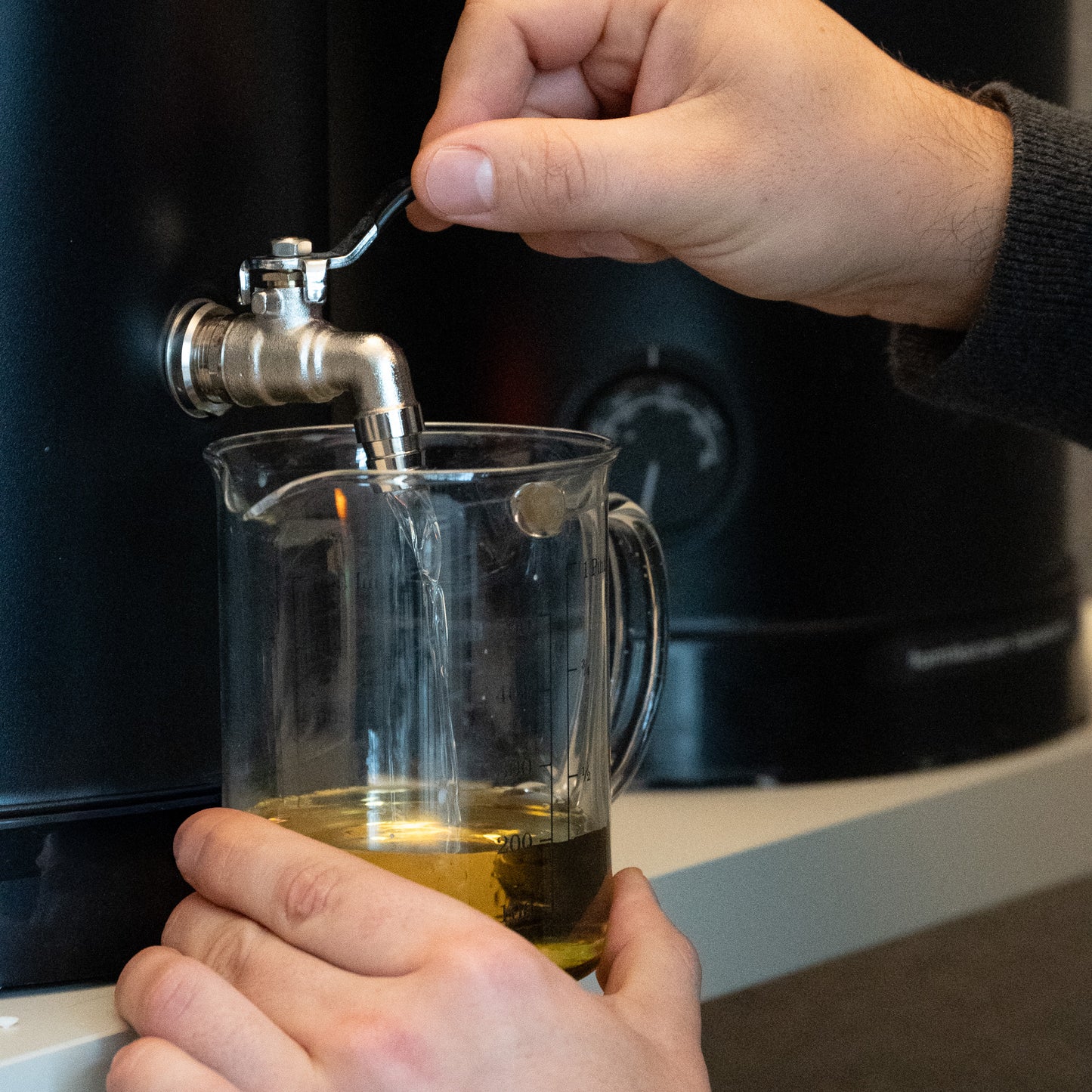 Mann füllt Wachs Rapswachs aus Behälter in Messbecher 