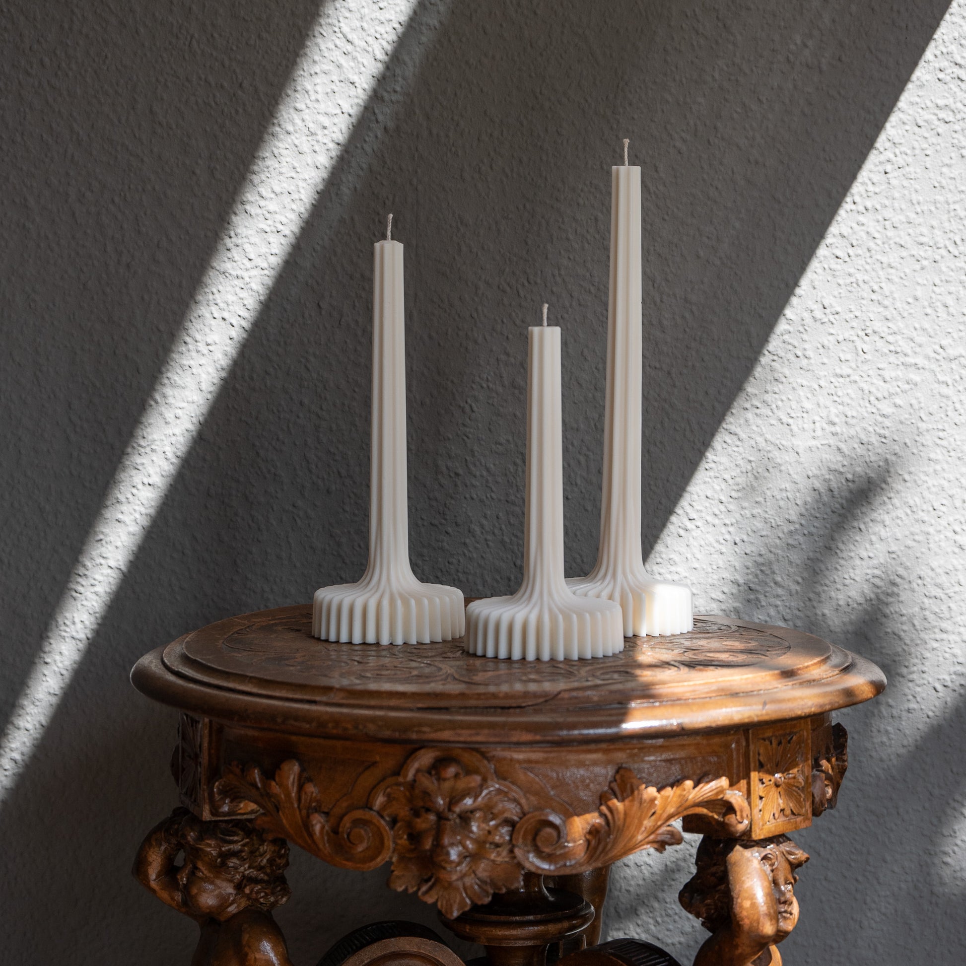 Kerzen Set Fylda in natürlichem Cremeton – skulpturale Designkerzen, Rapswachs, handgefertigt in Hamburg, 100 % pflanzlich & nachhaltig. Studio Z. Dreier Set mit aufstrebendem Stiel und skulpturalem Plateau. Dekoriert auf barockem Tisch im Schatten-Lichtspiel der Sonne.