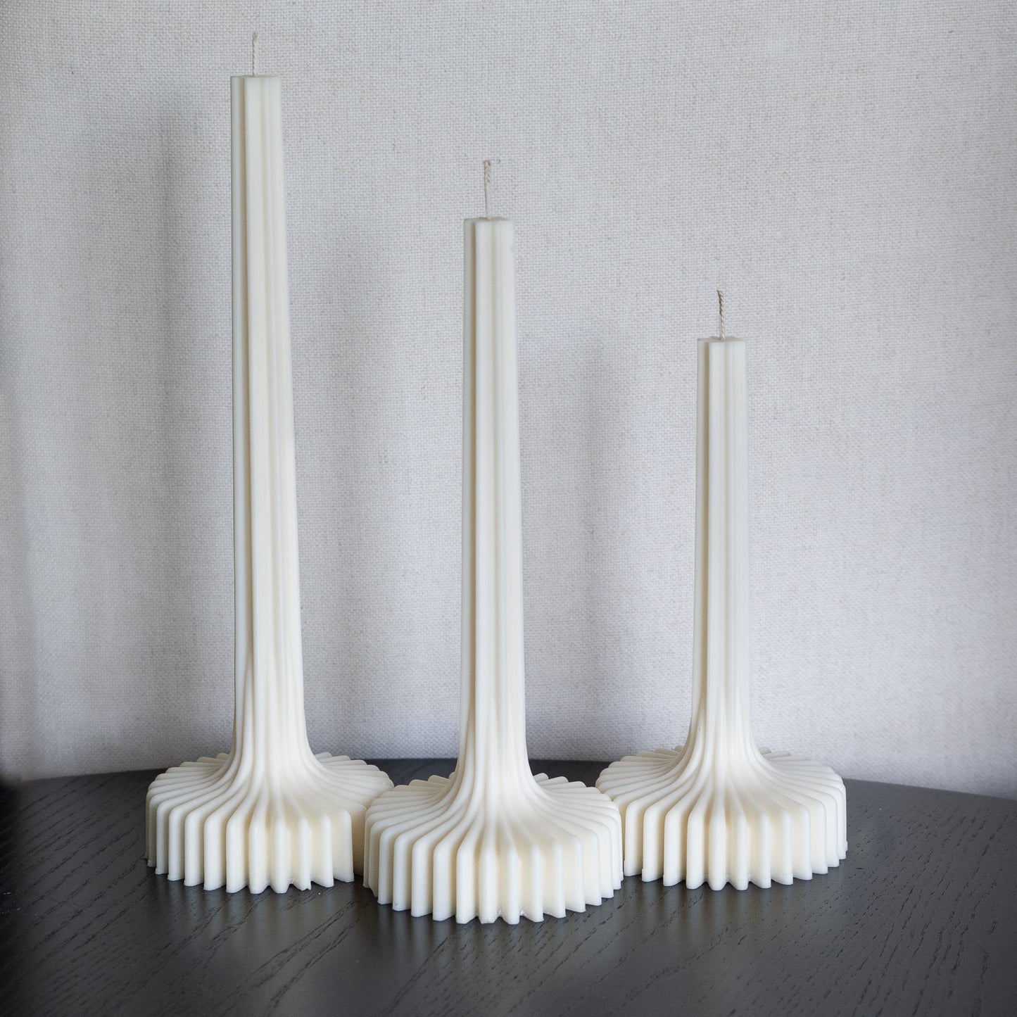 3er Kerzen Set Fylda in natürlichem Cremeton – skulpturale Designkerzen, Rapswachs, handgefertigt in Hamburg, 100 % pflanzlich & nachhaltig. Studio Z. Dreier Set mit aufstrebendem Stiel und skulpturalem Plateau. Dekoriert auf schwarzem Tisch vor Leinenstruktur.